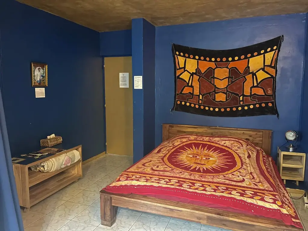 Chambre KOSMIK : murs bleu profond et batik soleil